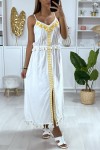 Long white dress with yellow embroidery and pompom.