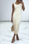 Long flowing beige dress with button on the front and slit at the back.