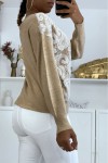 Beige V-neck sweater with white lace pattern.