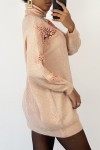 Long pink turtleneck sweater with openwork embroidery details.