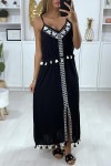 Long black dress with white embroidery and pompom.