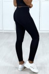 Legging noir en coton pour femme avec ouvertures et strass aux genoux.