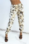 Flowing beige pants with tropical print tightened at the ankles