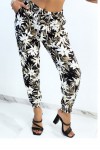 Flowing black trousers with tropical print tightened at the ankles
