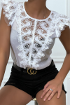 White top with lace on the front and flounce on the shoulders.