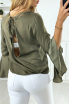 Women's khaki blouse open at the back with ruffles on the sleeves.