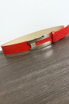 Cinturón rojo con hebilla rectangular y pedrería.
