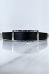 Cinturón negro con pedrería y hebilla rectangular plateada.