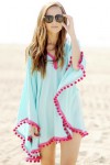 Turquoise poncho with pink pompoms