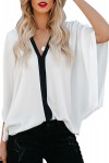 Blusa blanca con escote en pico negro.